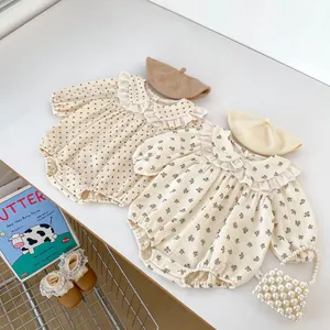 Detail of baby floral and polka dot rompers with lace collar and matching berets