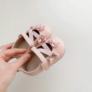 Dettaglio di scarpe Mary Jane rosa per neonata con fiocco e suola morbida per primi passi