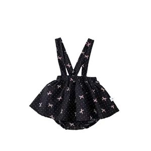 Robe barboteuse noire pour bébé fille avec nœuds roses et motif à pois blancs