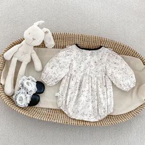 Detail of floral infant bodysuit with back buttons and cute lace socks in a basket