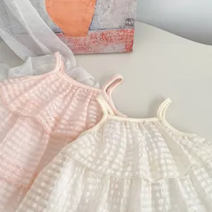 Nahaufnahme von kariertem Stoff mit zarter Bogenstickerei auf einem Etagenkleid