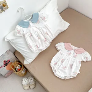 Detailed close-up of baby rompers with Peter Pan collars and cute bear patterns