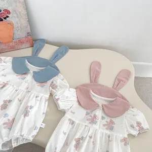 Detail of baby bodysuits with rabbit ear collars and bear prints in blue and pink colors