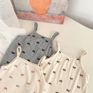 Detail of three rib-knit toddler camisoles with tiny bow prints in neutral tones