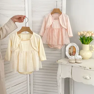 Close-up of baby girl lace mesh dress with bow detail and matching long sleeve cardigan