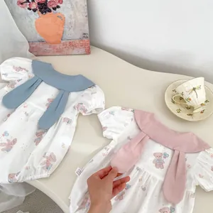 Close-up of cute baby romper featuring bunny ear collar and teddy bear print design