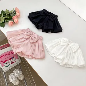 Detail of baby bloomers with oversized bow and ruffled hem in three pastel colors
