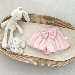 Close-up of pink baby bloomers with a large bow detail and a white size 73 tag