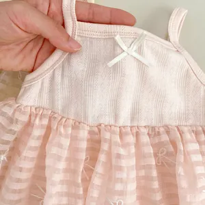 Detail of pink baby tutu dress featuring a knitted bodice and delicate white silk bow