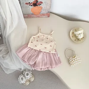 Detail of baby girl rib knit camisole and pleated shorts set with pink bow accents