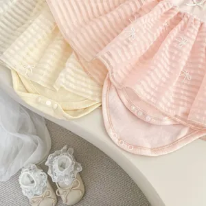 Detail view of baby girl romper dress with bow embroidery and lace pre-walker shoes