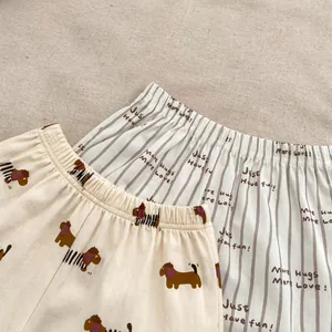 Dettaglio di pantaloncini in cotone per neonati con stampa di cani e motivi a righe