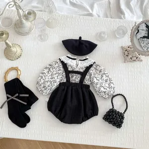 Détail d'un ensemble bébé avec chemisier floral et short à bretelles à col dentelle