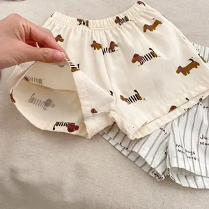 Dettaglio di pantaloncini per bambini in morbido cotone con cani e motivi a righe