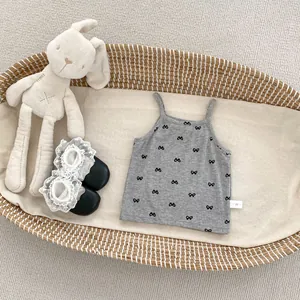 Detail of grey ribbed baby camisole with black bow prints and lace trim socks