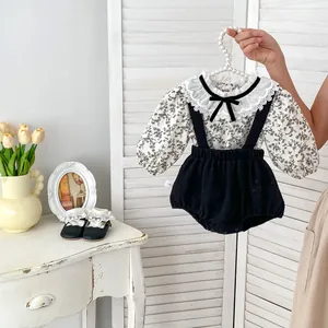 Détail du haut floral pour bébé avec col en dentelle et short à bretelles noir
