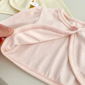 Close-up of baby pink cotton knit cardigan with breathable mesh texture and button detail