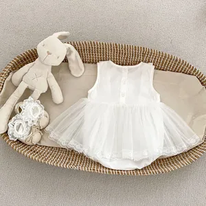 Detail of white infant tulle dress with delicate lace embroidery and back buttons