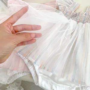 Detail of pink striped baby bodysuit showing breathable mesh fabric and snap closures