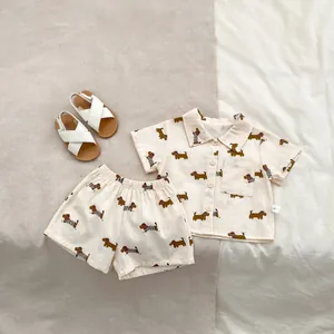 Dettaglio dell'anteprima del set estivo beige per neonati con stampe di bassotti marroni e tag