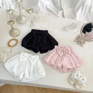 Flat lay of baby girls' bloomers in black, white, and pink with large bow details