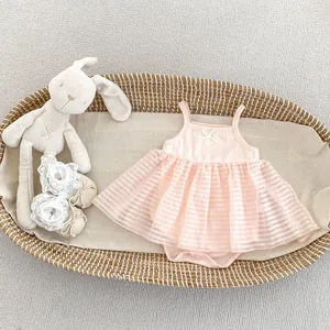 Detail of pink baby bodysuit with striped tulle skirt and matching lace floral shoes