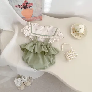 Detalle plano de camisa floral para bebé y pantalones verdes con tirantes suaves