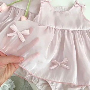 Detail of pink baby dress with tulle fabric and satin bow for princess party outfit