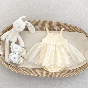 Detailed flat lay of baby girl mesh romper with lace bow shoes in a woven basket
