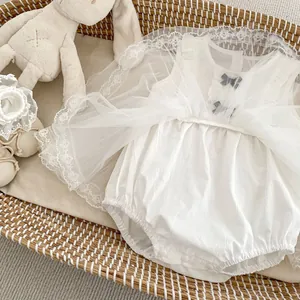 Detailed view of baby white lace romper with mesh tutu, tiny bows and matching soft shoes