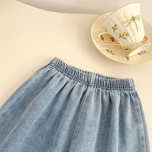 Detailed view of girls light blue denim skirt with elastic waistband and floral embroidery