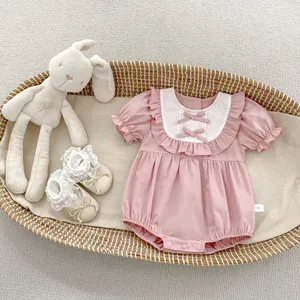 Détail du barboteuse rose pour bébé avec col en dentelle blanche, nœuds et taille 66