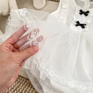 White infant mesh bodysuit dress with lace trim and black bows for summer occasions