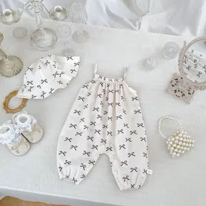 Flat lay of baby girl romper with bow print including a matching sun hat and vintage decor