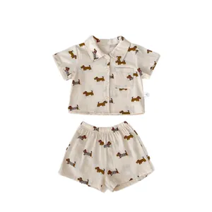 Simpatico completo beige da bambino in cotone con stampe di bassotti e camicia con revers
