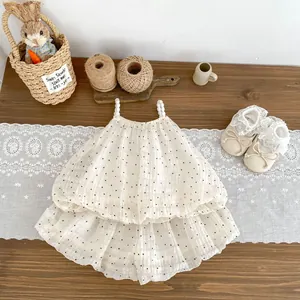 Detailed view of polka dot baby dress with pearl straps and matching lace bow shoes