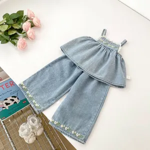 Detailed close-up of denim girls set with floral embroidery and white lace trim edges