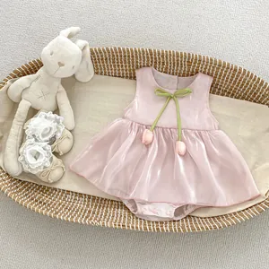 Detail of pink baby romper dress with green bow tie and 3D tulip floral decorations