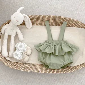 Pelele para bebé verde salvia con volantes, zapatos de encaje y conejo en una cesta