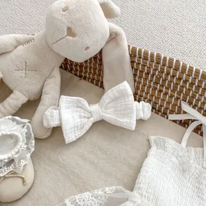 Détail de barboteuse en dentelle pour bébé avec bandeau assorti et chaussons souples
