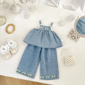 Detailed embroidery and white lace trim on a girl's denim camisole and wide-leg pants set