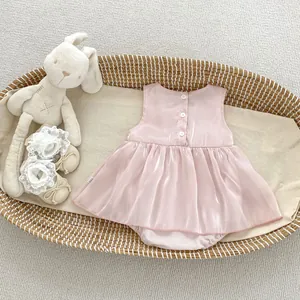 Close-up of pink baby dress back with functional white buttons and smooth fabric texture