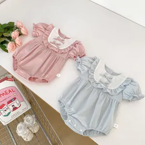 Détail de barboteuses pour bébé roses et bleues avec col volanté et nœuds déco