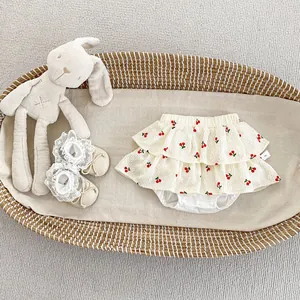 Detail of cherry print bloomer skirt with elastic waist and snap buttons for baby girls