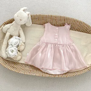 Detail view of pink baby romper dress with back buttons and sleeveless silk-like finish