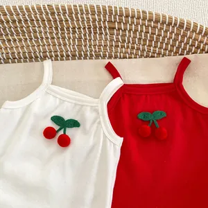 Detail of baby camisole featuring handmade knitted cherry accents on ribbed cotton fabric