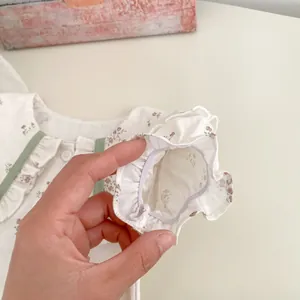 Detalle de camisa floral para bebé con puños elásticos con volantes y diseño retro