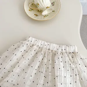 Detail of baby girl's polka dot shorts with elastic waistband and textured white fabric