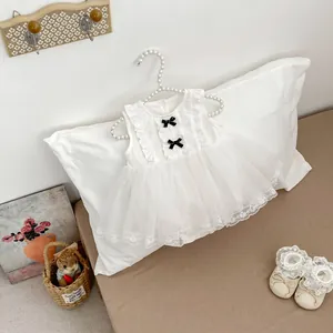 Detailed close-up of baby girl tulle dress with lace hem and decorative black bows