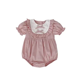 Barboteuse bébé rose avec manches bouffantes blanches et nœuds pour l'été